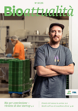 Copertina di Bioattualità 10|25: Un uomo guarda nella telecamera con le braccia incrociate, sullo sfondo c'è una persona che lavora su un impianto.